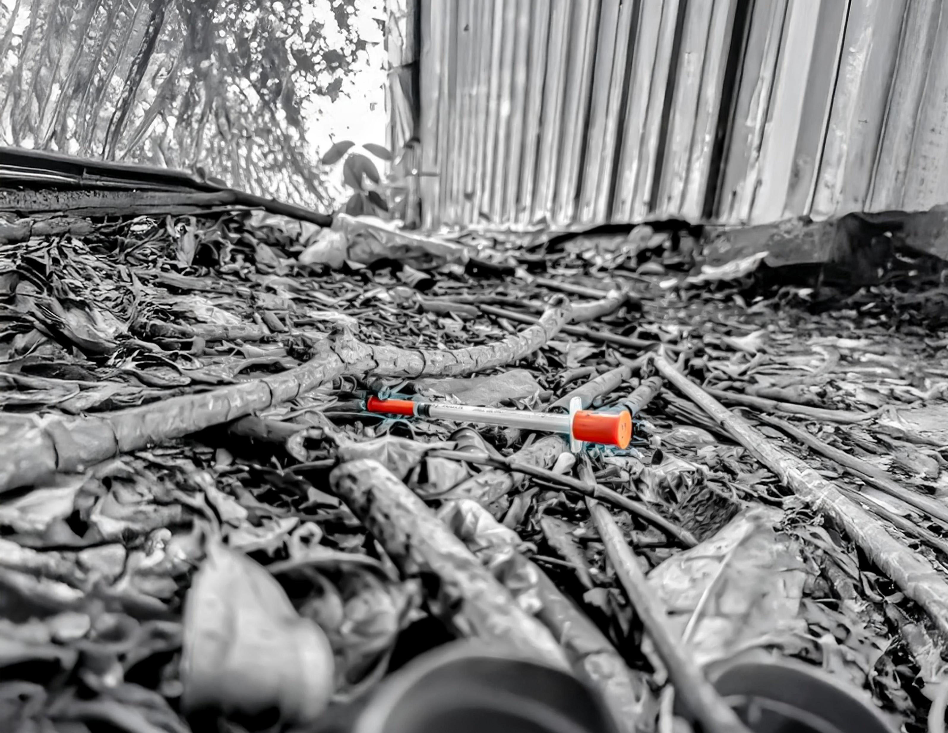 Discarded drug paraphernalia on the ground.